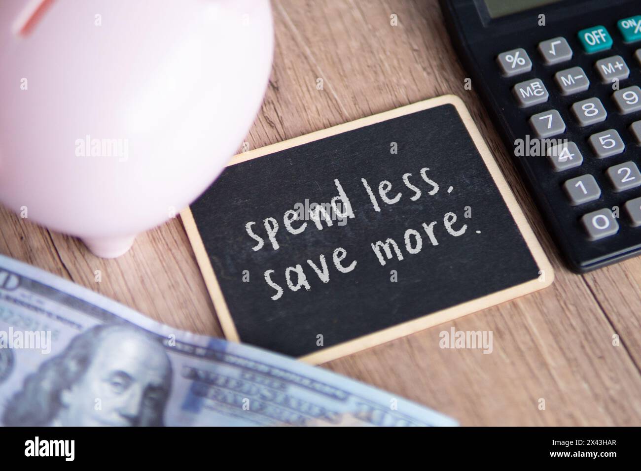 Draufsicht des Schwarzen Bretts mit Text WENIGER Geld und WENIGER Geld SPAREN. Stockfoto