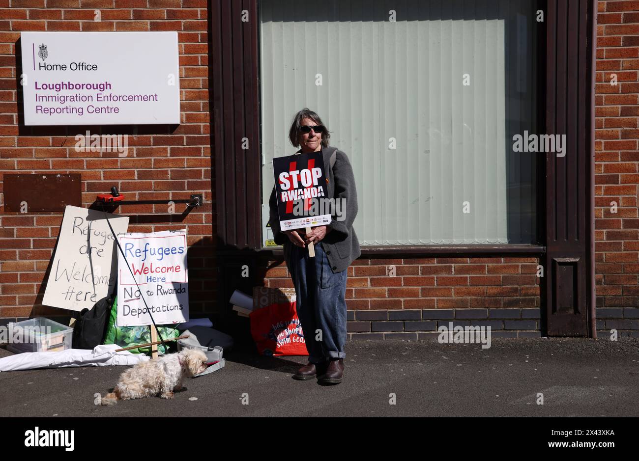 Loughborough, Leicestershire, Großbritannien. 30. April 2024. Ein Demonstrant, der gegen die geplante Deportation von Migranten und Flüchtlingen nach Ruanda demonstriert, steht vor einem Meldezentrum für Einwanderungsbehörden. Credit Darren Staples/Alamy Live News. Stockfoto