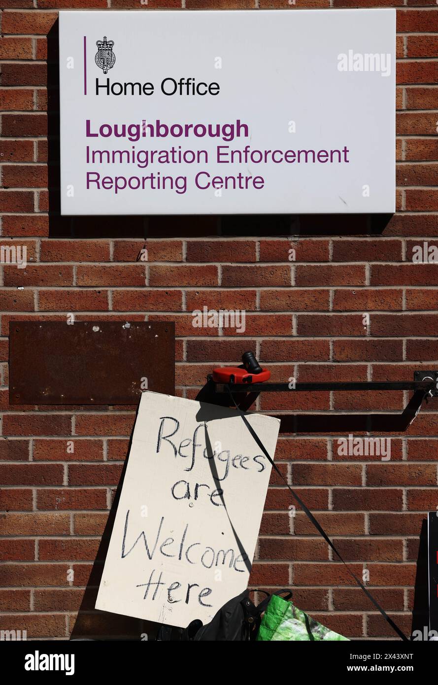 Loughborough, Leicestershire, Großbritannien. 30. April 2024. Ein Banner steht vor einem Meldezentrum für Einwanderungsbehörden, während Demonstranten gegen die geplante Deportation von Migranten und Flüchtlingen nach Ruanda protestieren. Credit Darren Staples/Alamy Live News. Stockfoto