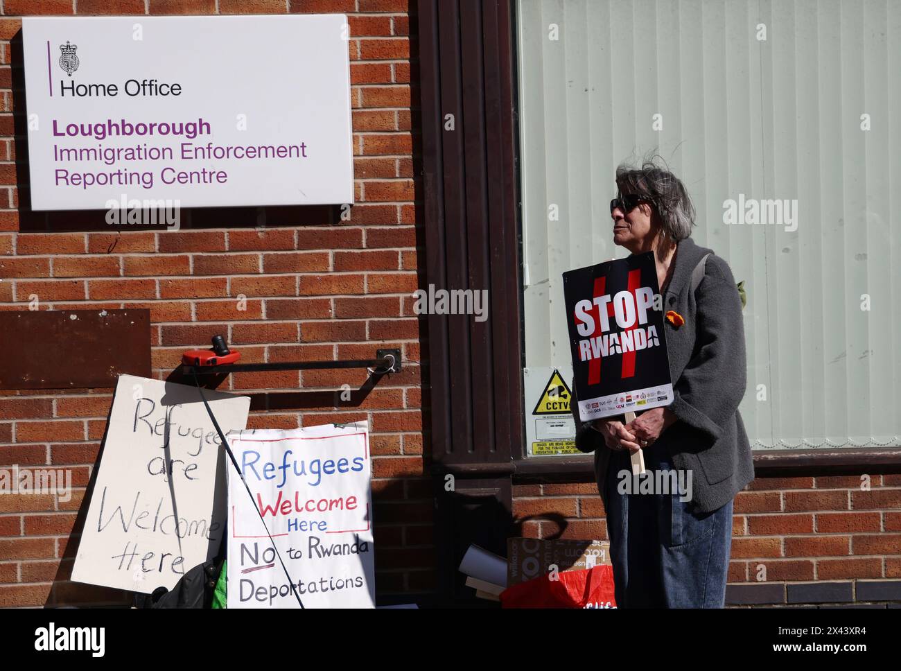Loughborough, Leicestershire, Großbritannien. 30. April 2024. Ein Demonstrant, der gegen die geplante Deportation von Migranten und Flüchtlingen nach Ruanda demonstriert, steht vor einem Meldezentrum für Einwanderungsbehörden. Credit Darren Staples/Alamy Live News. Stockfoto