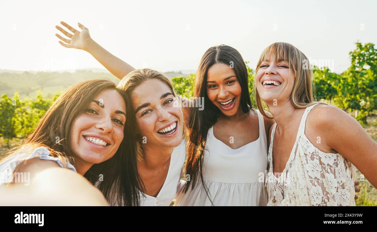 Gruppe von Freundinnen, die während der Sommerferien Selfie auf dem Land machen, mit Weinbergen im Hintergrund - Sommerurlaub, Party und Reisekonzept - Stockfoto