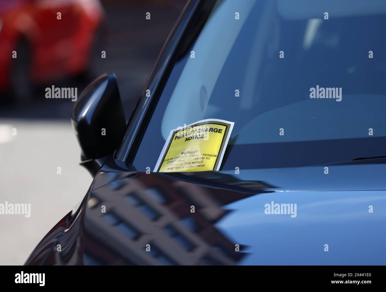 Loughborough, Leicestershire, Großbritannien. 30. April 2024. Ein Hinweis auf eine Strafgebühr, der an der Windschutzscheibe eines Autos hängt, das auf gelben Doppellinien geparkt ist. Stockfoto