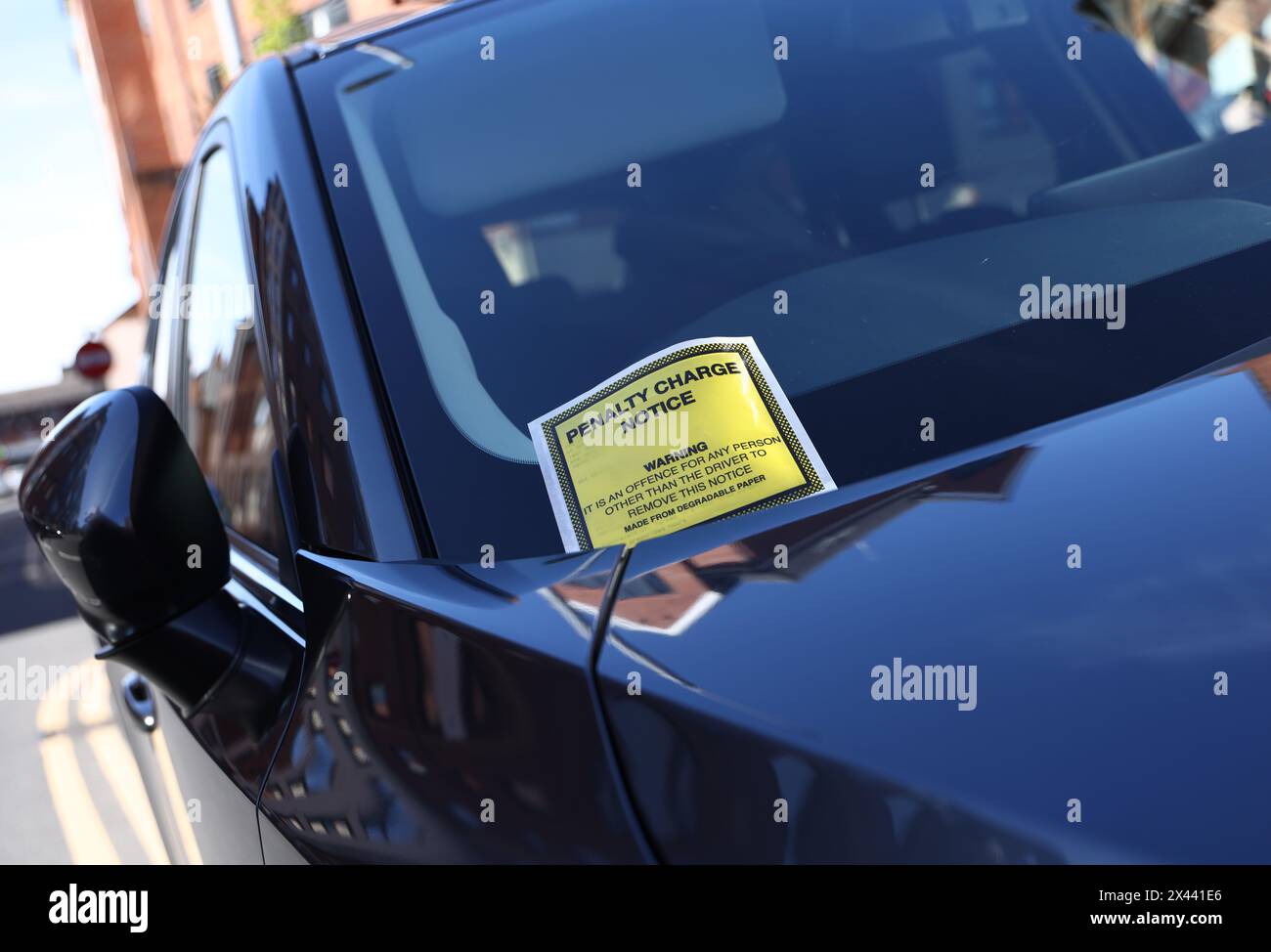 Loughborough, Leicestershire, Großbritannien. 30. April 2024. Ein Hinweis auf eine Strafgebühr, der an der Windschutzscheibe eines Autos hängt, das auf gelben Doppellinien geparkt ist. Stockfoto