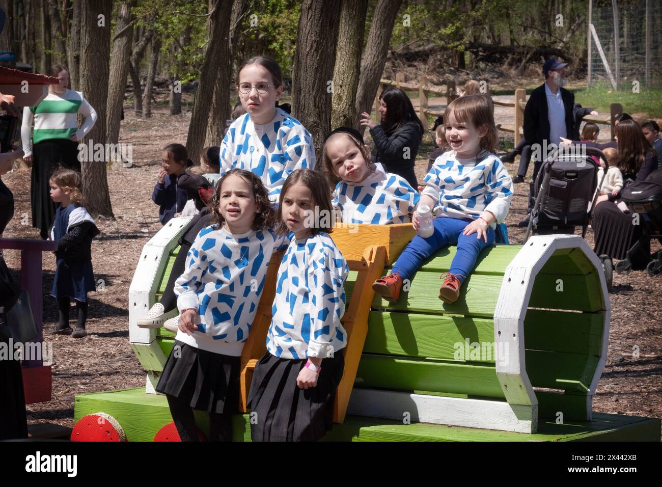Eine chassidische jüdische Familie mit Kindern, die identische Oberteile tragen, posieren für ein Foto während des Pessach. Auf einer Farm im Rockland County. Stockfoto
