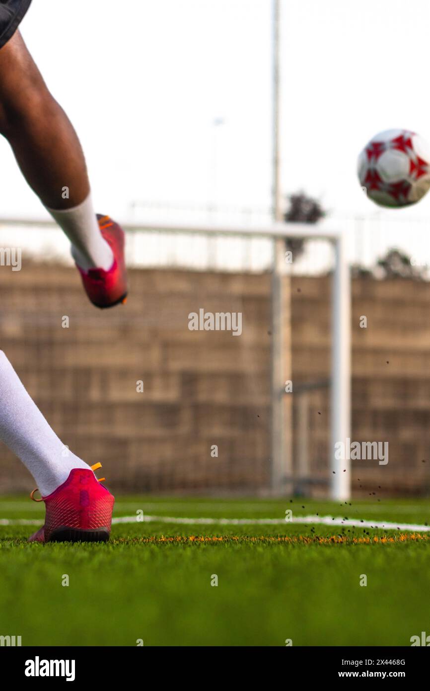 Fußballspieler Füße laufen mit dem Ball vor dem Feld. Spieler Füße mit dem Ball, der ein Tor erzielt. Fußballspieler auf dem Spielfeld, der mit läuft Stockfoto