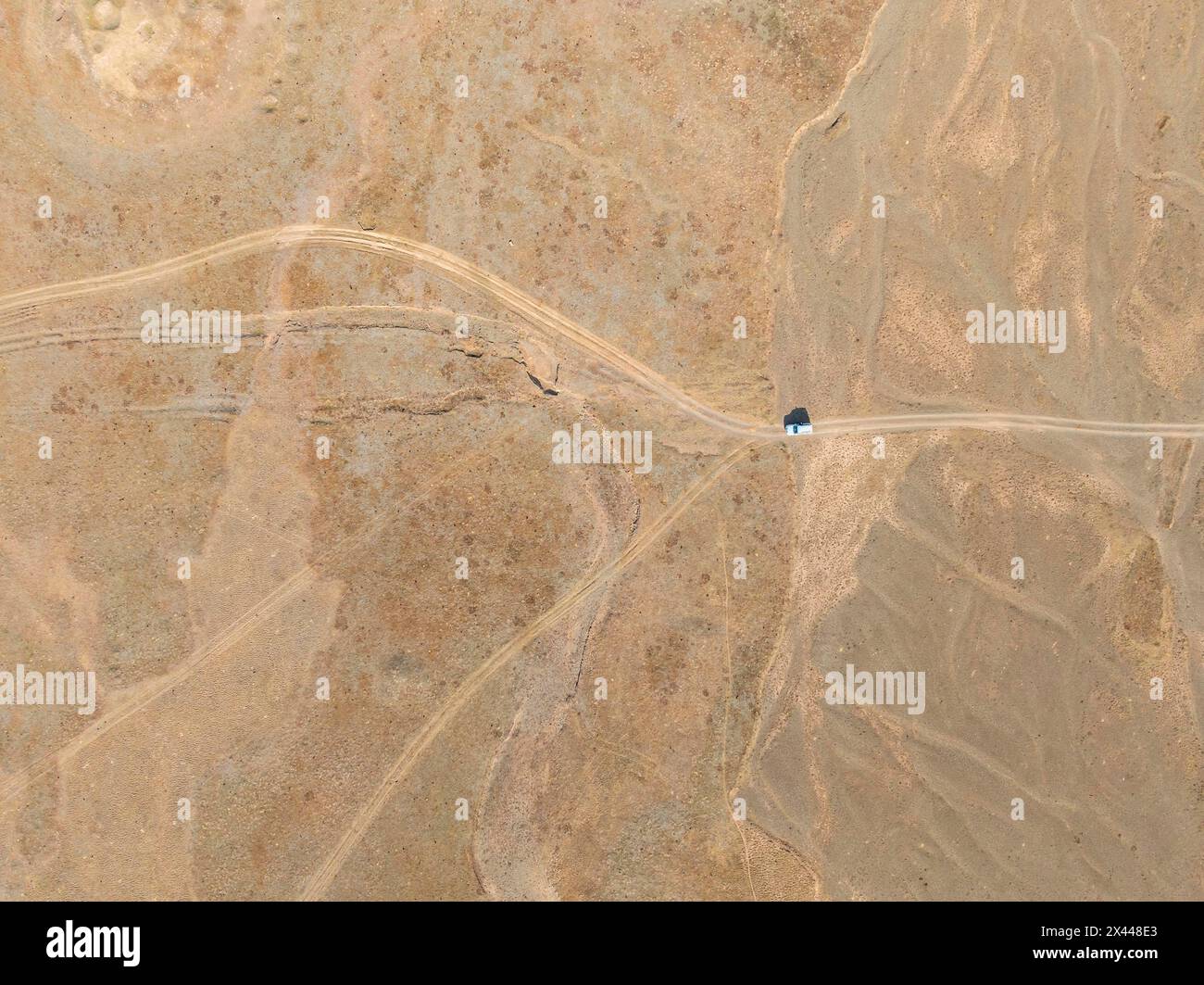 Aus der Luft, weite, leere Landschaft, Straßen- und Geländewagen, Ansicht von oben nach unten, zwei Wege teilen sich, symbolisch für Entscheidungen, Moldo Too Mountains, Naryn Stockfoto