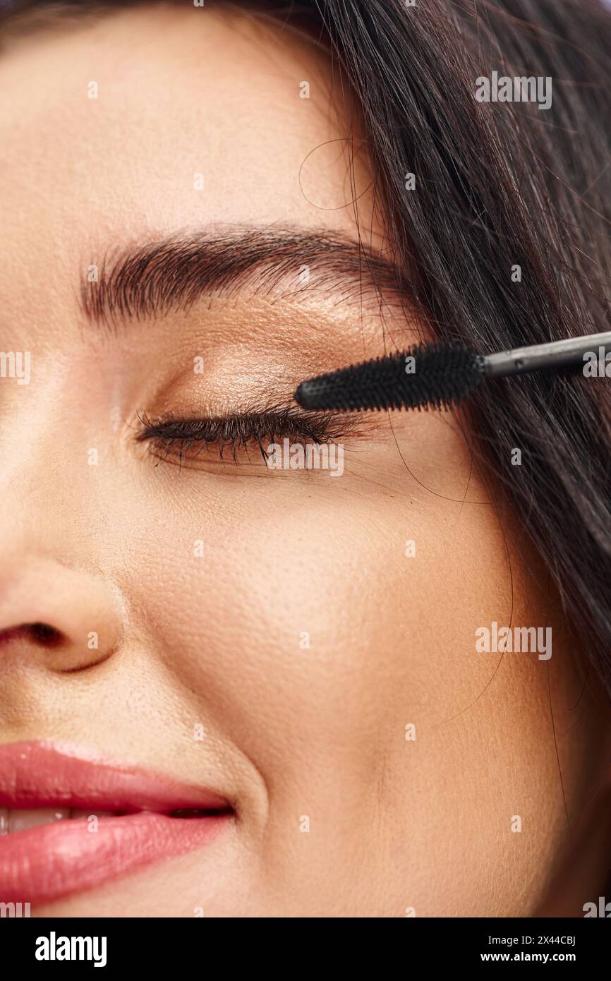 Eine Frau, die mit einer Mascara perfektioniert und die natürliche Schönheit betont. Stockfoto