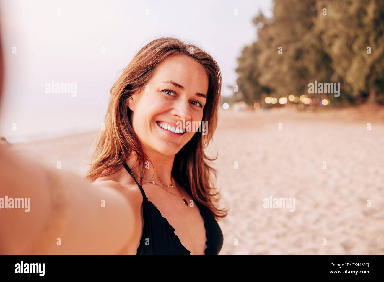 Porträt einer lächelnden Reifen Frau, die Selfie am Strand macht Stockfoto