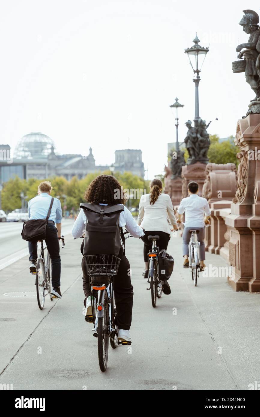 Männliche und weibliche Geschäftsangestellte pendeln durch den Radweg auf der Brücke in der Stadt Stockfoto