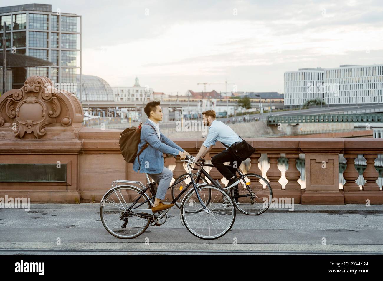 Männliche Geschäftsleute, die mit dem Fahrrad in der Stadt zum Büro pendeln Stockfoto