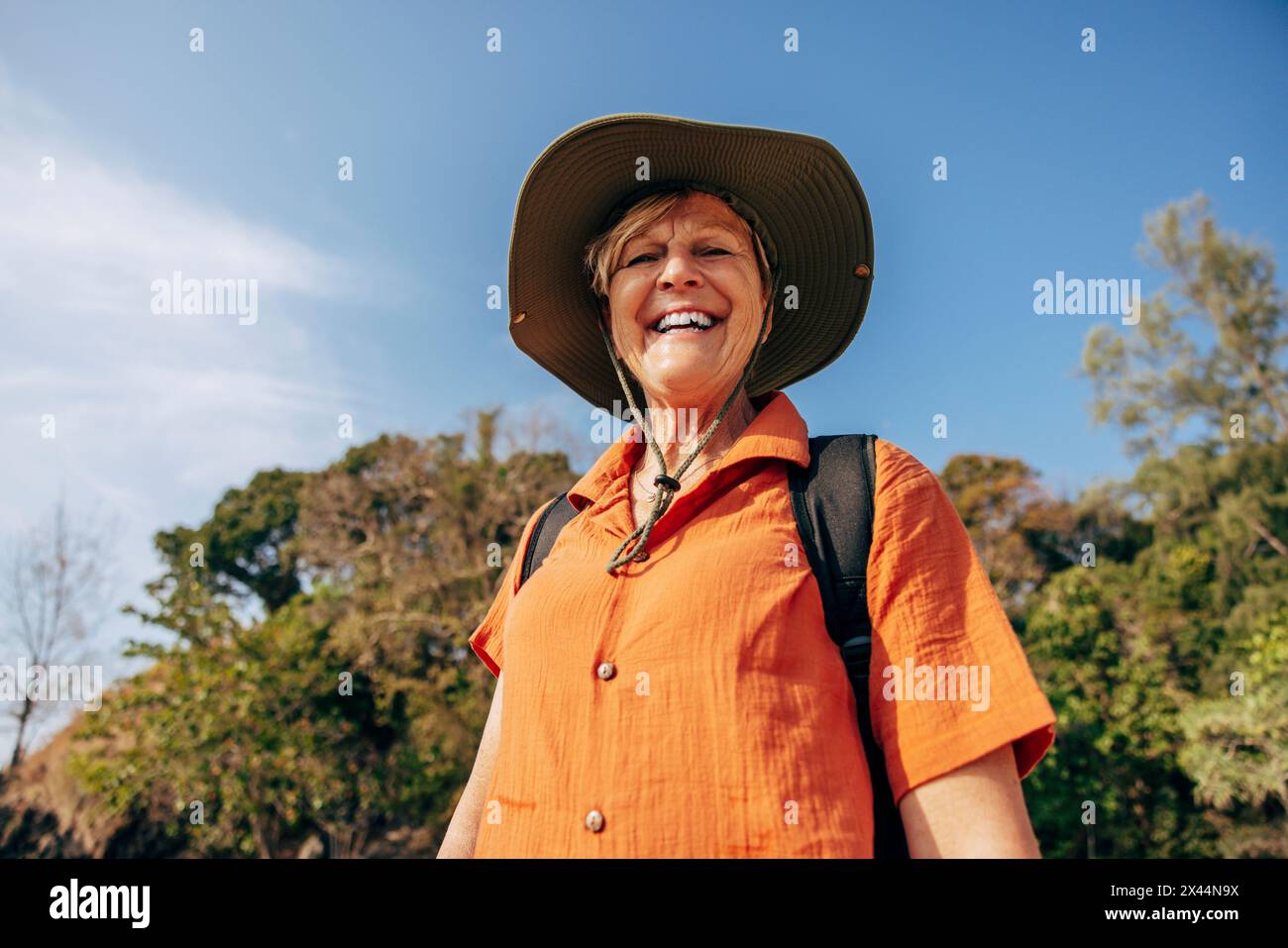 Niedrigwinkelporträt einer lächelnden Seniorin, die im Urlaub am Himmel steht Stockfoto