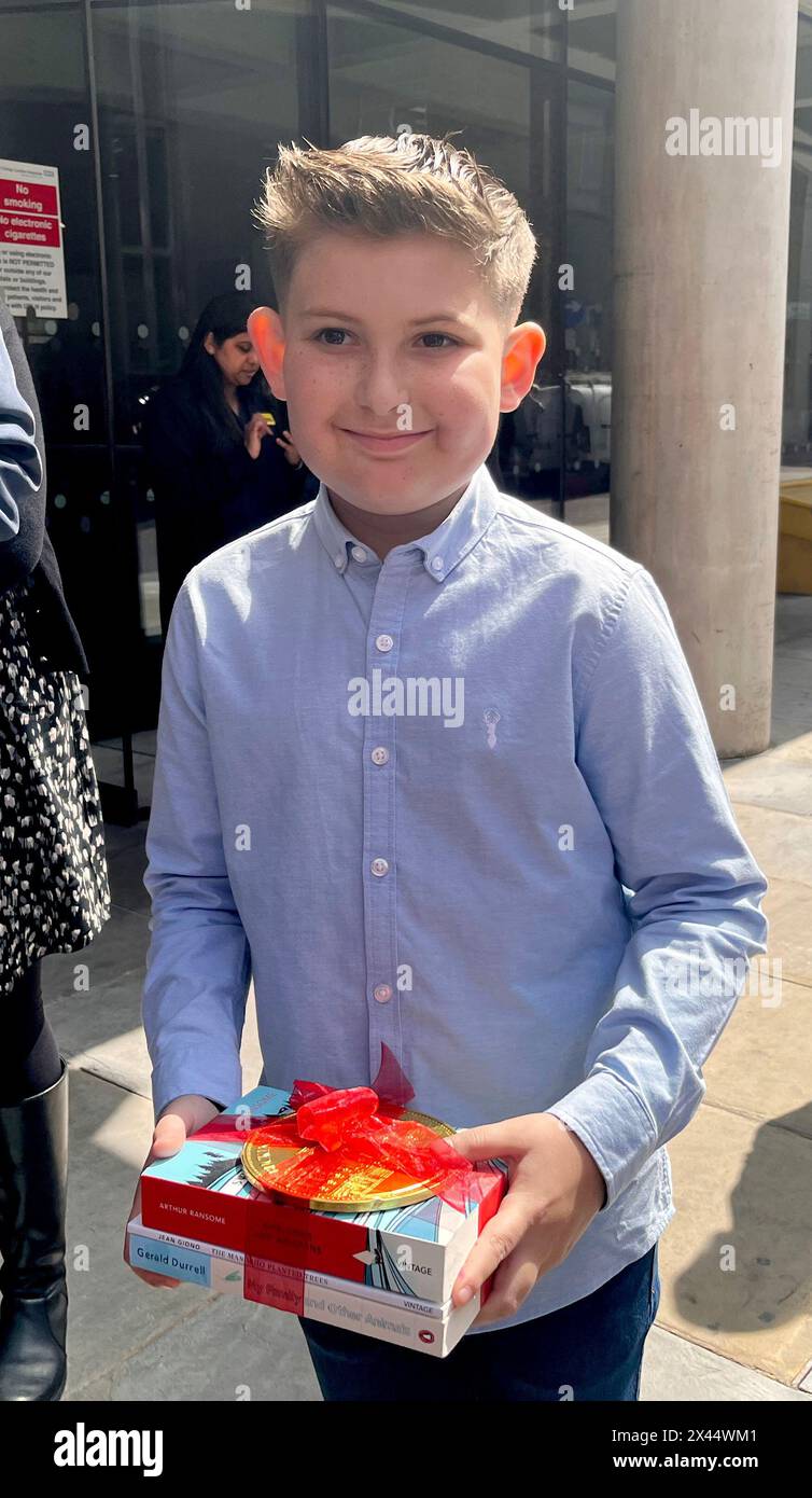 Ellis Edwards, 11, hielt drei Bücher und eine beschriftete Buckingham Palace Schokoladenmünze, die ihm König Charles III. Und Königin Camilla während ihres Besuchs im University College Hospital Macmillan Cancer Centre in London geschenkt haben. Bilddatum: Dienstag, 30. April 2024. Stockfoto