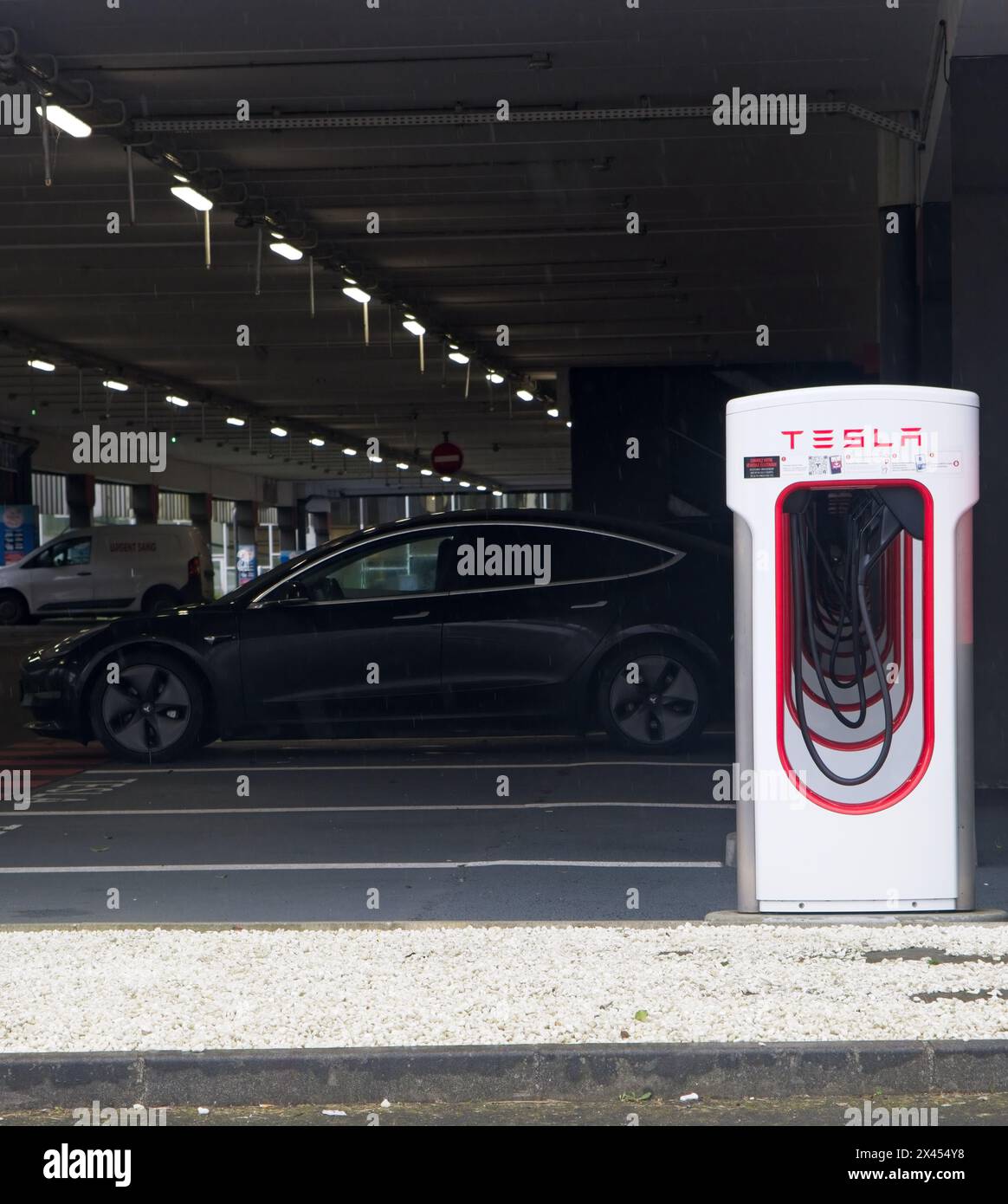 Brest, Frankreich - 7. April 2024: Eine statische Aufnahme eines soliden schwarzen Tesla Model 3 Doppelmotors beim Brest V3 Superchager an einem regnerischen Frühlingstag. Wählen Sie Aus Stockfoto