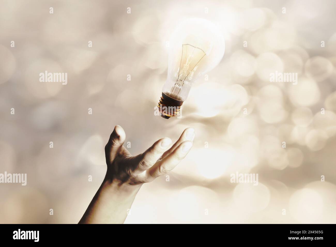 Surreal beleuchtete Glühbirnenfliegen, die von einer Person geworfen werden, Idee und kreative Energie Stockfoto