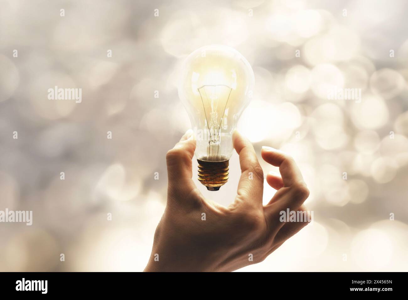 Person, die eine surreale Glühbirne in der Hand hält, Idee und Energie Stockfoto