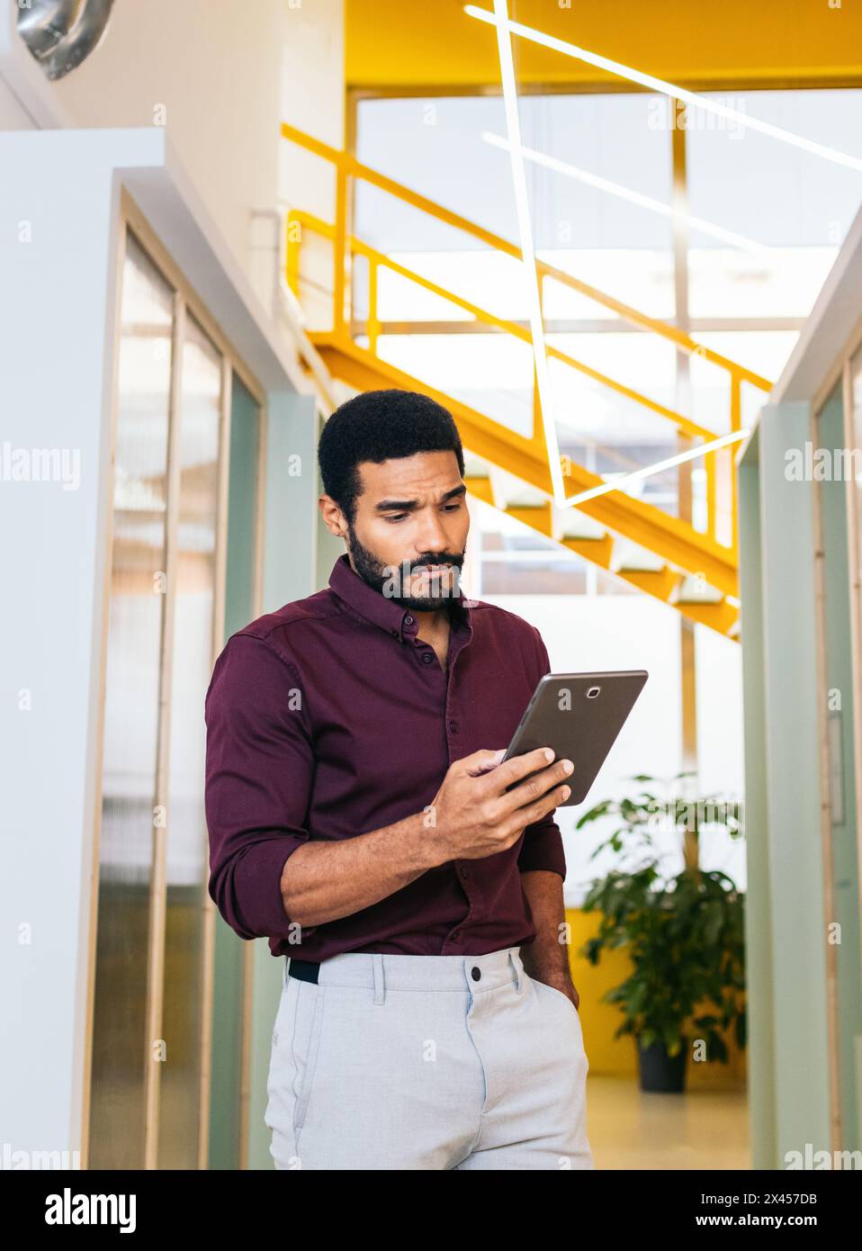 Hübscher lateinmann im Hemd, der mit einem Tablet in einem Coworking arbeitet Stockfoto