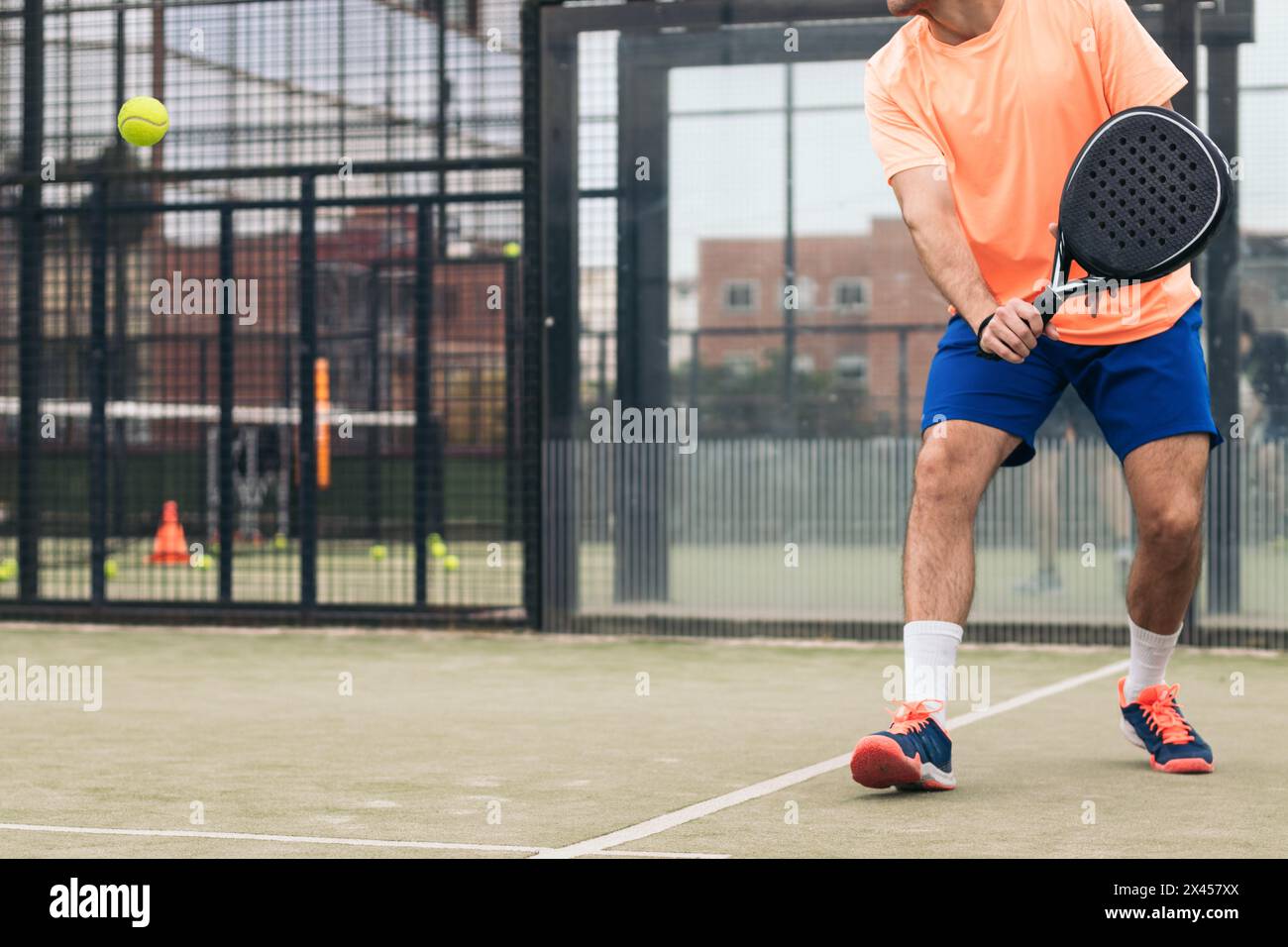 Junger Mann, der Paddle-Tennis spielt Stockfoto