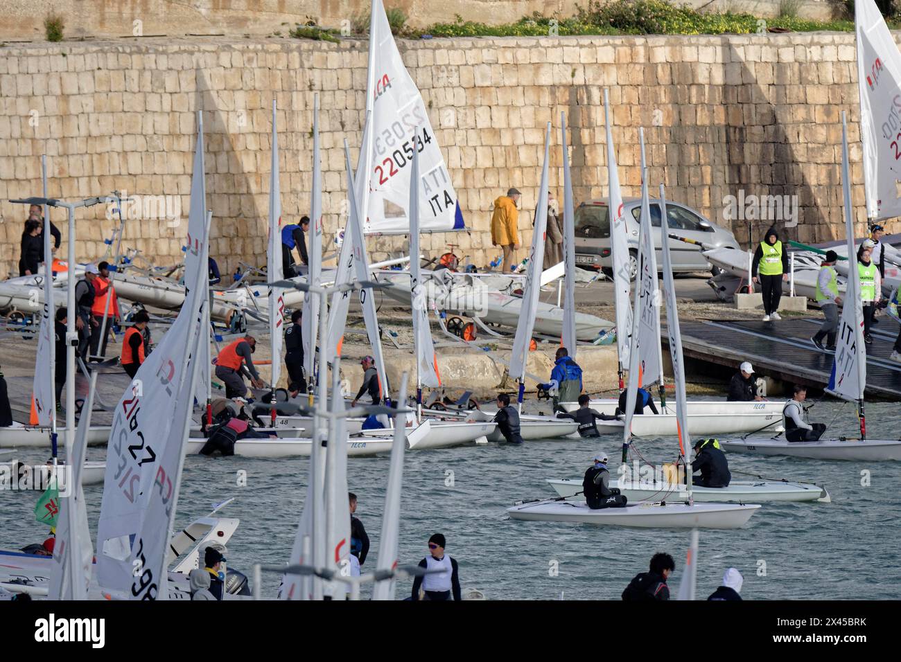 Italien, Sizilien, Mittelmeer, Marina di Ragusa; 11. Februar 2024, Menschen und Segeljollen im Hafen - EDITORIAL Stockfoto