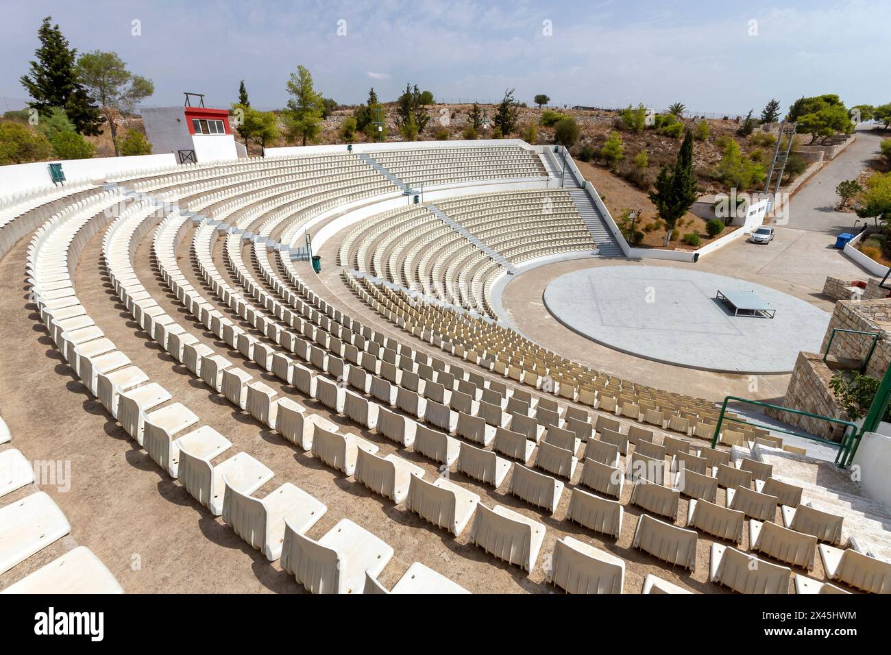 Öffentliches Freilufttheater mit perfekter halbrunder Form und vielen Reihen weißer Plastikstühle auf der Insel Salamina, Griechenland. Stockfoto