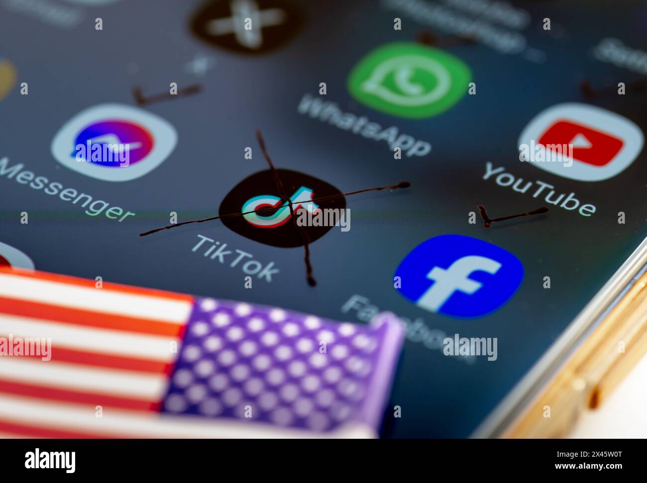 London. UK- 04.26.2024. Ein US-TikTok-Ban-Konzept mit der App auf dem Bildschirm eines Smartphones mit einem Kreuz. Eine US-Flagge an der Seite und ein Häkchen darauf Stockfoto