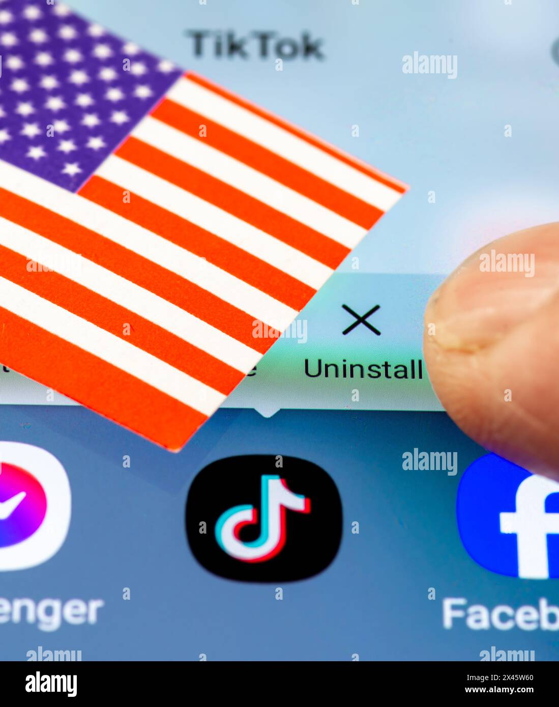 London. UK- 04.26.2024. Ein US-TikTok-Ban-Konzept mit der chinesischen App auf dem Bildschirm eines Android-Telefons, der US-Flagge und einem Finger, der die UNO drückt Stockfoto
