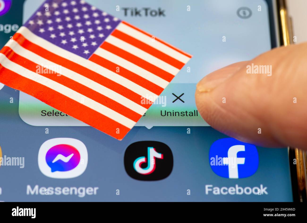 London. UK- 04.26.2024. Ein US-TikTok-Ban-Konzept mit der chinesischen App auf dem Bildschirm eines Android-Telefons, der US-Flagge und einem Finger, der die UNO drückt Stockfoto