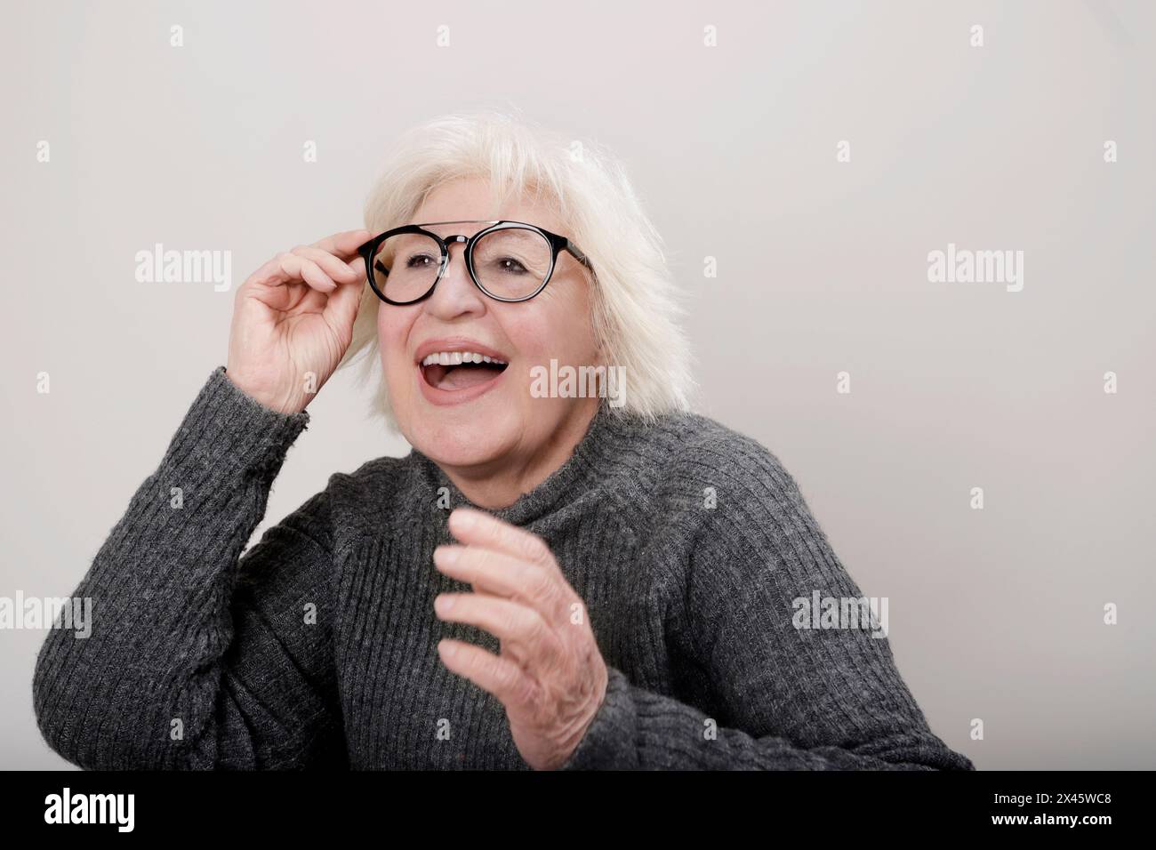 Ältere grauhaarige Frau mit überraschtem Ausdruck Stockfoto