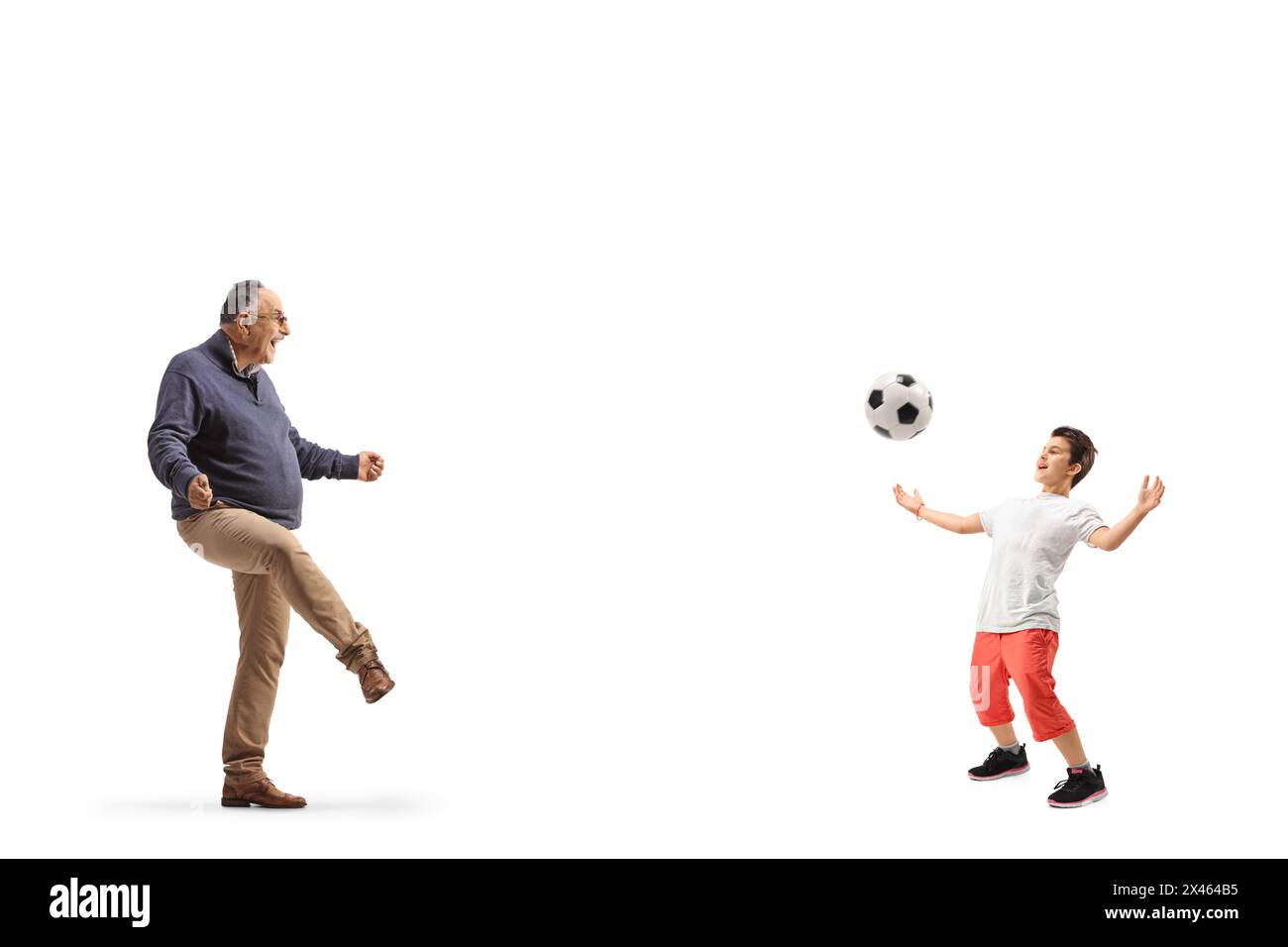 Profilaufnahme eines zwanglosen, Reifen Mannes, der mit einem Jungen Fußball spielt, isoliert auf weißem Hintergrund Stockfoto