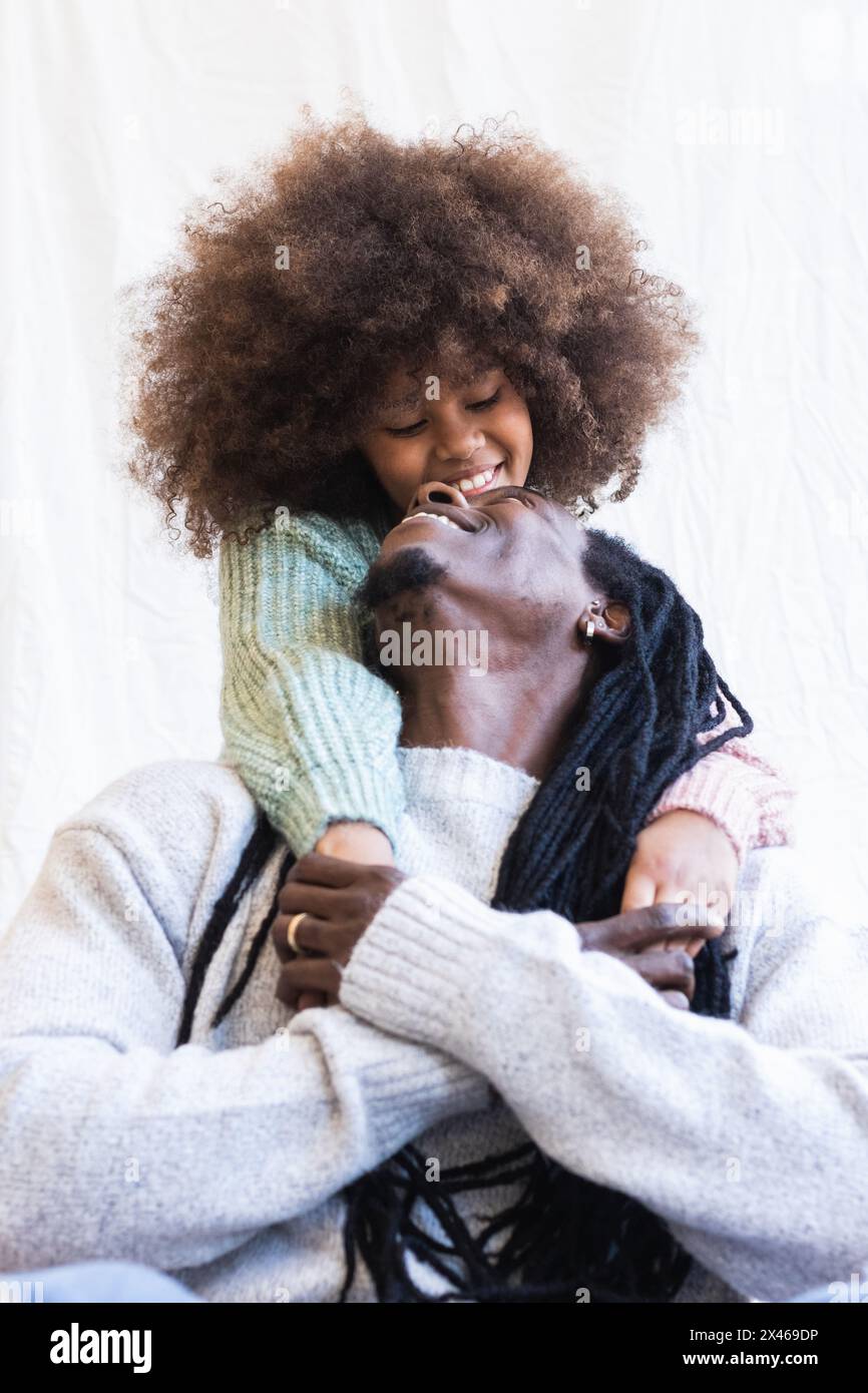 Positive afroamerikanische Mädchen umarmt Papa mit Dreadlocks während mit Gute Momente zusammen Stockfoto