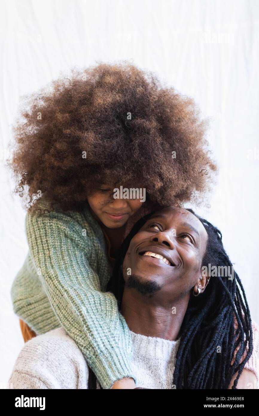 Positive afroamerikanische Mädchen umarmt Papa mit Dreadlocks während mit Gute Momente zusammen Stockfoto
