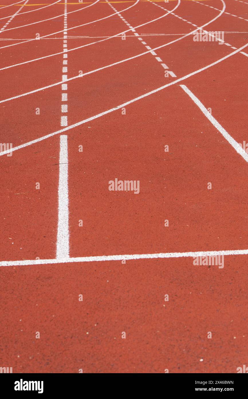 Nahaufnahme einer roten Leichtathletikbahn mit weißer Spurmarkierung und granularer Textur in einem Outdoor-Sportzentrum in Paris Stockfoto