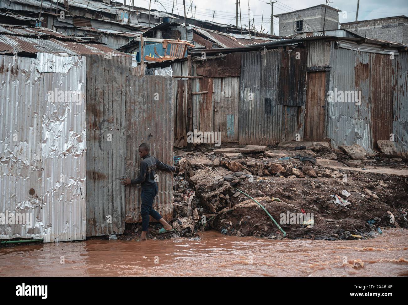 Nairobi, Kenia. April 2024 30. Ein Junge versucht, am 30. April 2024 durch ein überflutetes Gebiet in den Slums von Mathare in Nairobi, Kenia, zu laufen. Starke Regenfälle, die mehrere Teile Kenias heimgesucht haben, und verheerende Sturzfluten haben 169 Menschen getötet, sagte ein Regierungsbeamter. Quelle: Wang Guansen/Xinhua/Alamy Live News Stockfoto