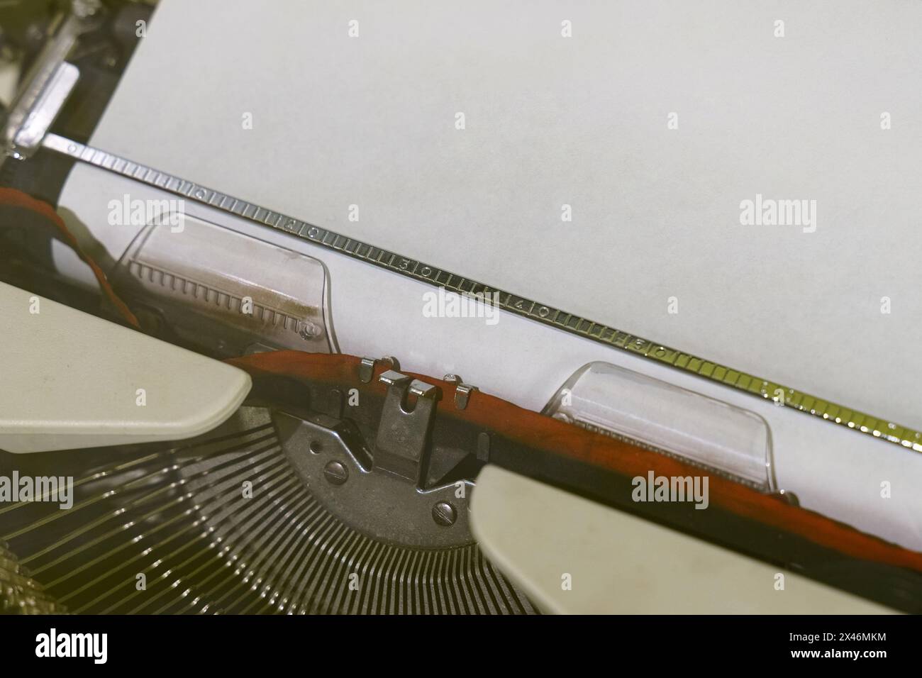Eine detaillierte Ansicht einer altmodischen Schreibmaschine mit Papier, die das klassische Design und die Funktionalität dieses Schreibgeräts erfasst. Stockfoto