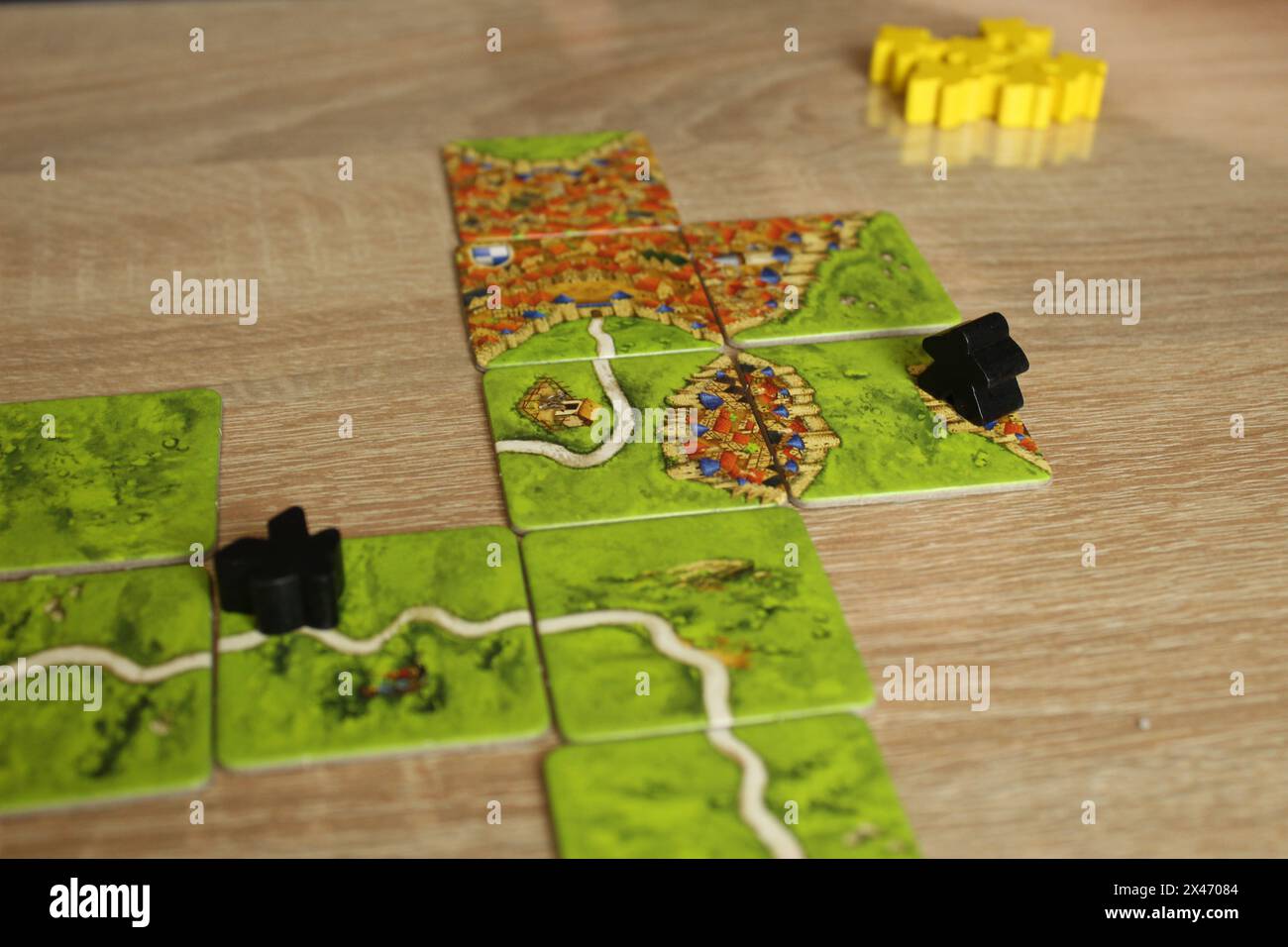 Mozyr, Weißrussland, 03. April 2024: Brettspiel carcassonne. Feld mit schwarzen Meeples auf der Feldstraße. Spielerbewertungsregel. Stockfoto