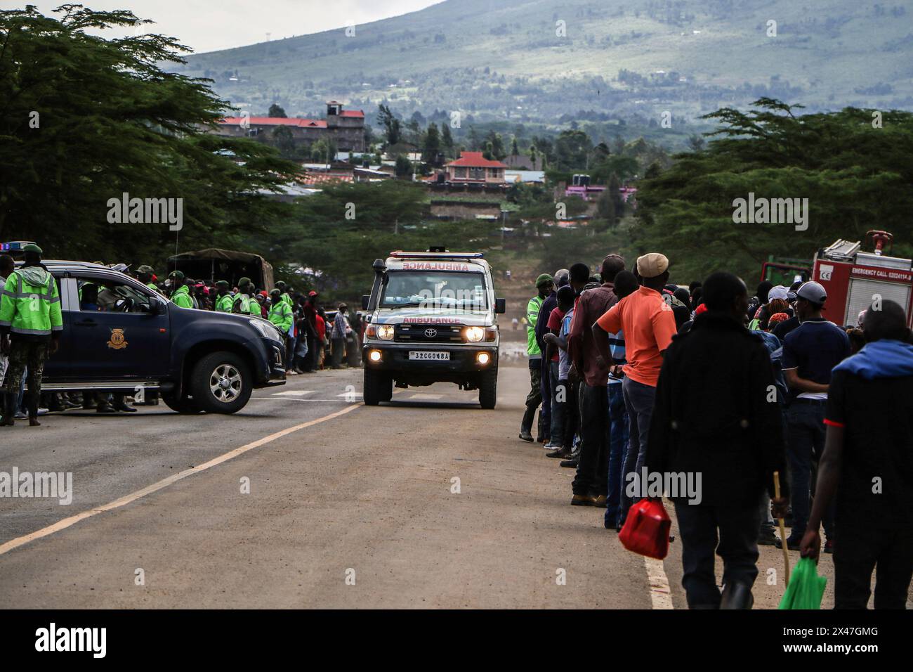 Nakuru, Kenia. April 2024 30. Ein Krankenwagen mit Hochwasseropfern wird an einer Menschenmenge vorbeigefahren, die am Straßenrand steht. Such- und Rettungseinsätze sind nach einer Überschwemmungskatastrophe in Mai Mahiu im County Nakuru im Gange. Über 50 Tote wurden gemeldet. (Foto: James Wakibia/SOPA Images/SIPA USA) Credit: SIPA USA/Alamy Live News Stockfoto