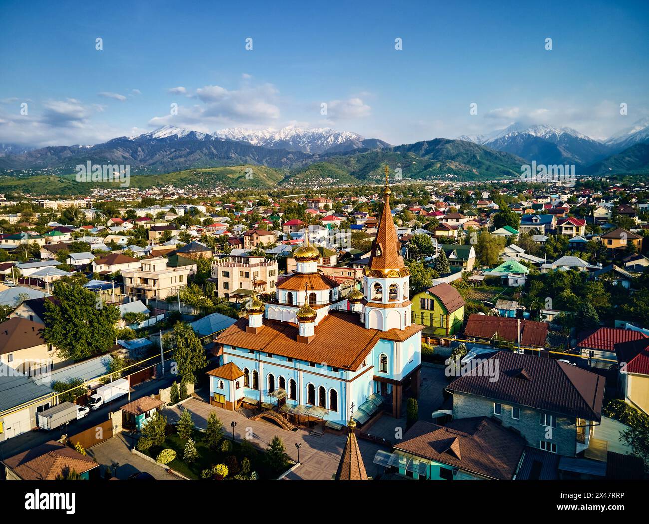 Luftdrohne von oben nach unten von der russisch-orthodoxen Kirche der Kathedrale mit Schnee-Berg-Hintergrund in Almaty Stadt, Kasachstan Stockfoto