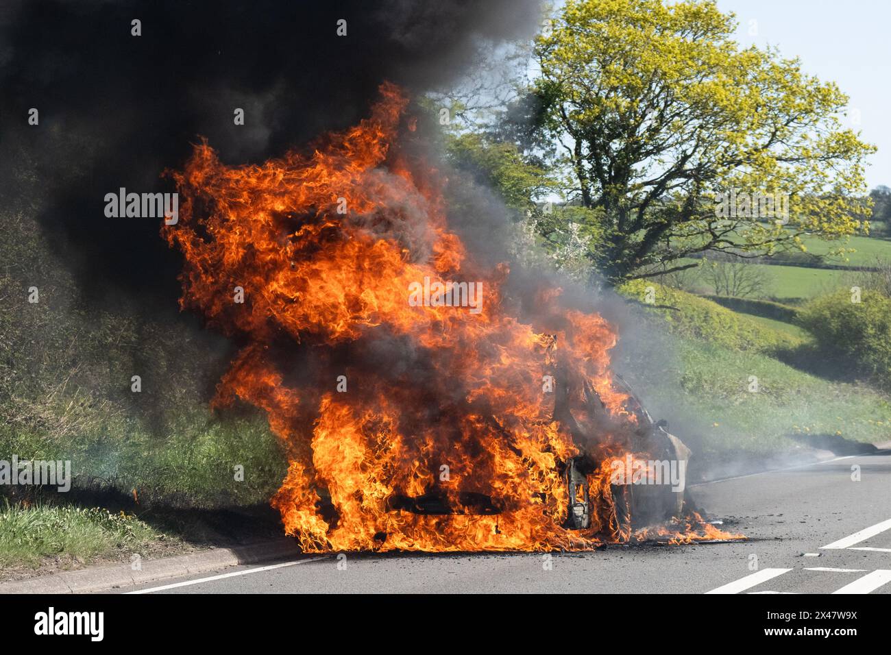 Brennendes Auto am Straßenrand - Großbritannien Stockfoto