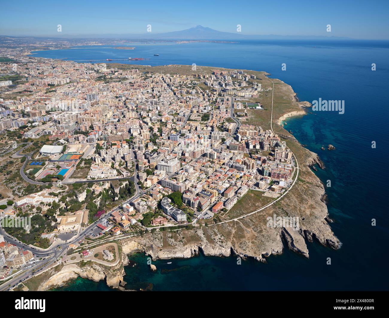 LUFTAUFNAHME. Die Stadt Syrakus mit dem Ätna in der Ferne. Provinz Syrakus, Sizilien, Italien. Stockfoto
