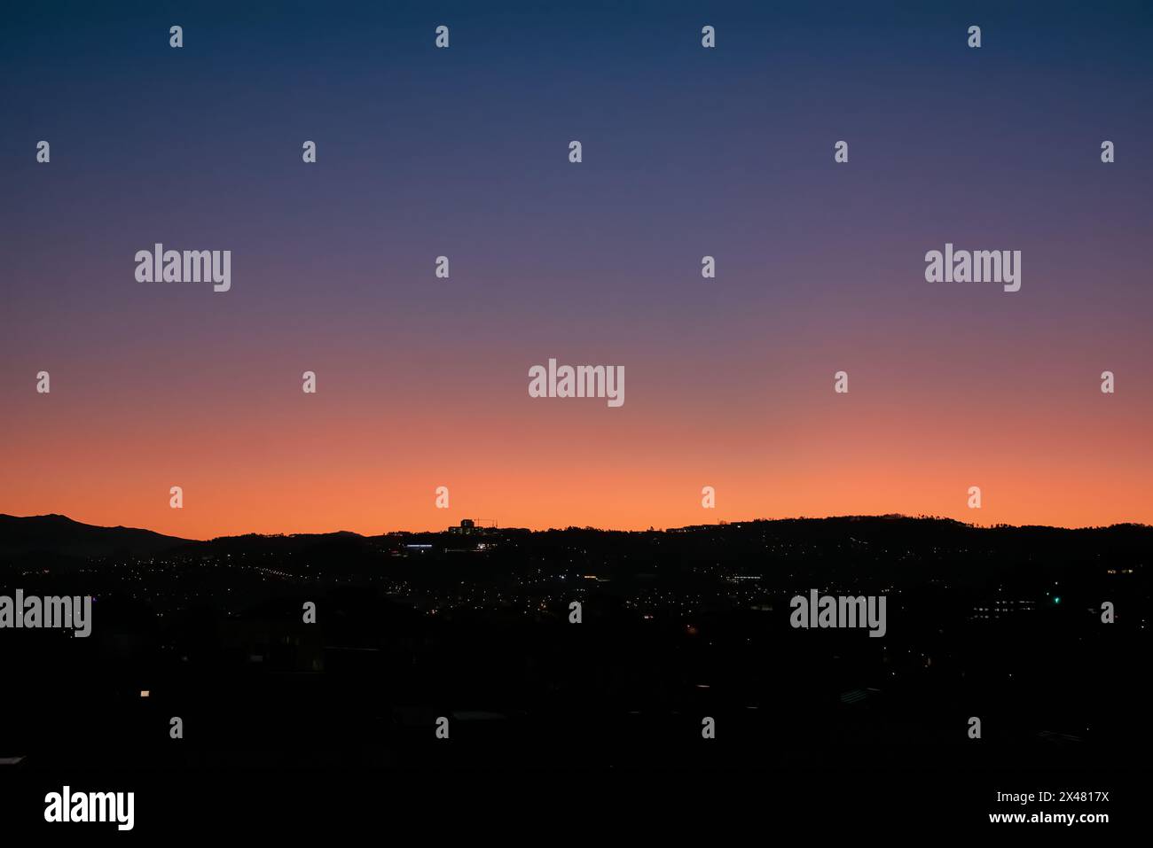 Silhouette von Bergen und Gebäuden unter dem Himmel bei Sonnenaufgang Stockfoto