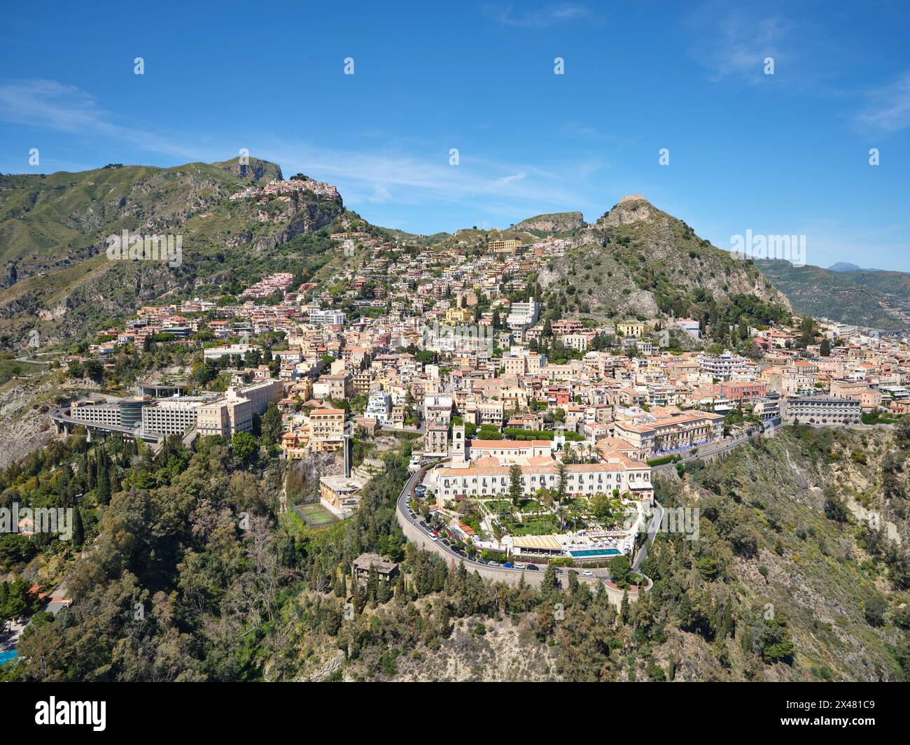 LUFTAUFNAHME. Die touristische Stadt Taormina und oben links das Dorf Castelmola auf einem Hügel. Metropolitanstadt Mesina, Sizilien, Italien. Stockfoto