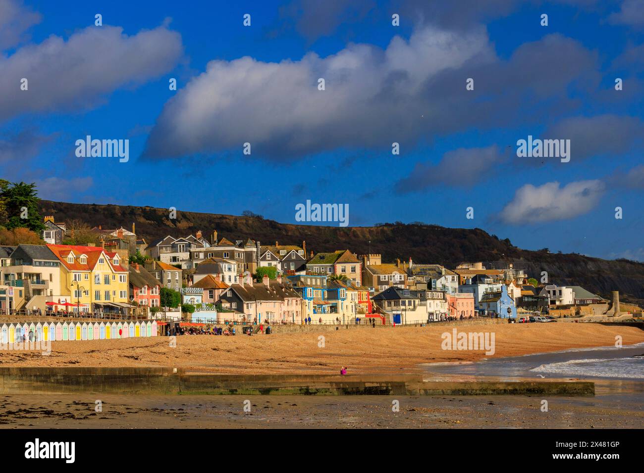 Die Wintersonne beleuchtet die Häuser und Ferienhäuser entlang der Küste in Lyme Regis, Dorset, England, Großbritannien Stockfoto