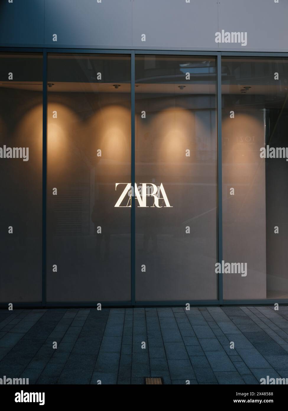 Ein leeres Zara-Schaufenster mit Logo und Lichtern. Stockfoto