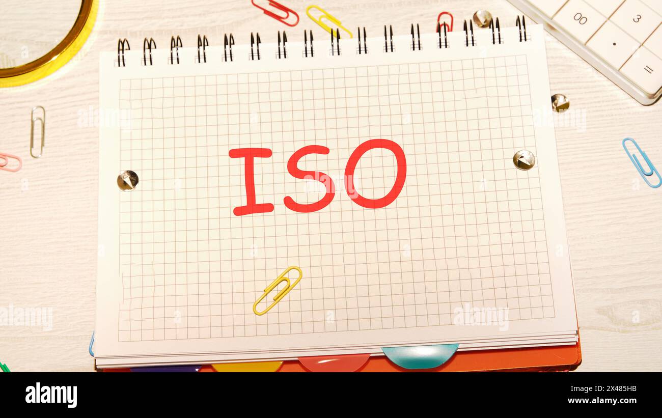 Das Konzept der ISO-Qualitätskontrollzertifizierung. Abkürzung ISO in einem karierten Notizbuch geschrieben Stockfoto