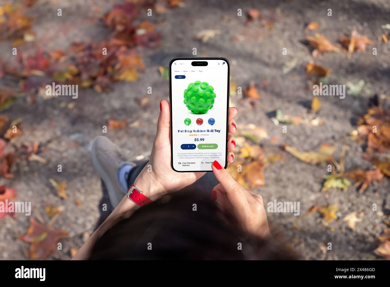 Frau, die auf dem Smartphone die E-Commerce-App für Haustiere durchsucht und das niedliche Hundespielzeug auswählt. Tierhandlung online mit Lebensmitteln und Spielzeug Stockfoto