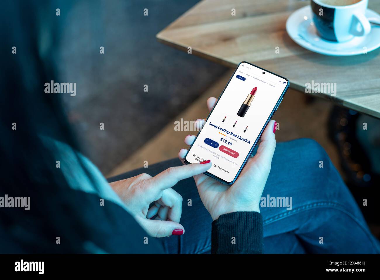 Frau kauft Kosmetik, roten Lippenstift online mit Smartphone im Café. Müheloses Einkaufen in der Kosmetik Stockfoto
