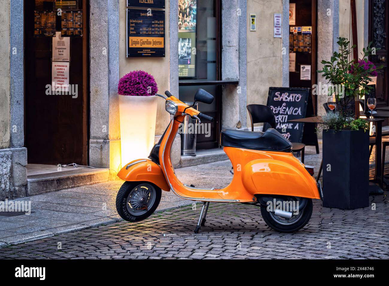 Vespa Special Piaggio in Vintage-Orange parkte vor einer Bar in einer italienischen Kopfsteinpflasterstraße. Stadt Udine, Region Friaul-Julisch Venetien, Italien. Stockfoto