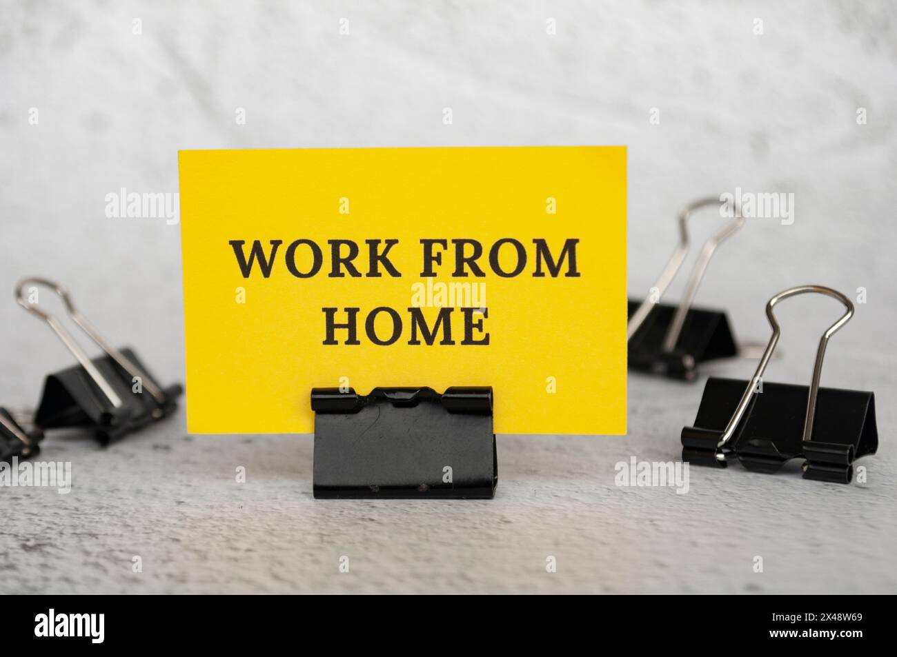 Arbeiten Sie von zu Hause aus auf stehendem gelbem Papier. Arbeitskultur-Konzept. Stockfoto