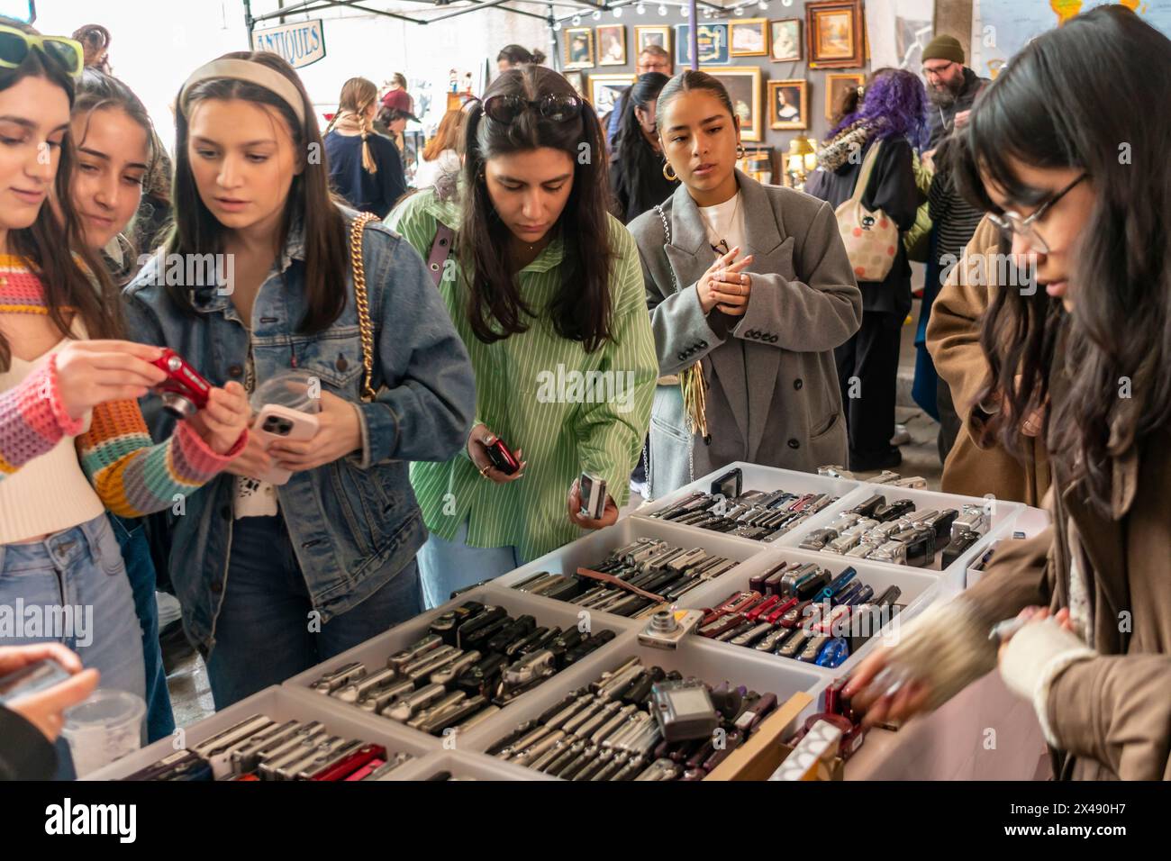 Frauen der Generation Z kaufen am Samstag, den 27. April 2024, auf einem Flohmarkt in der Nachbarschaft Dumbo in Brooklyn in New York ältere Digitalkameras. (© Richard B. Levine) Stockfoto