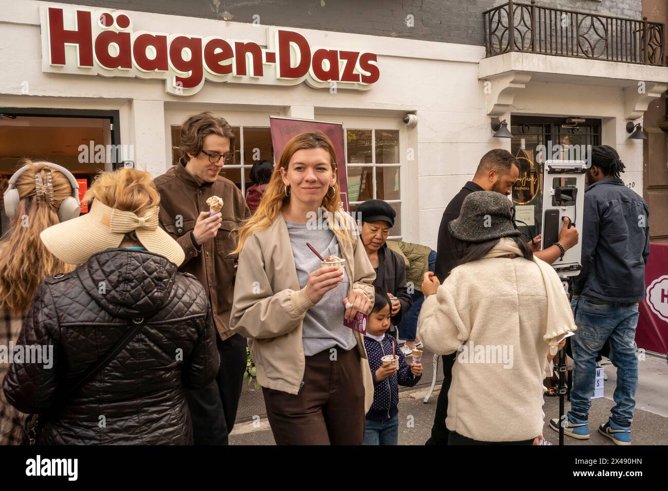 Die Menschen stehen für kostenlose Schaufeln HŠagen-Dazs-Eiscreme an, um die Wiedereröffnung ihres Geschäfts in Brooklyn Heights in New York am Samstag, den 27. April 2024, zu feiern. Der Laden ist der erste Laden, der 1976 von der Eisdichterei eröffnet wurde. HŠagen-Dazs ist eine Marke von General Mills. ( © Richard B. Levine) Stockfoto