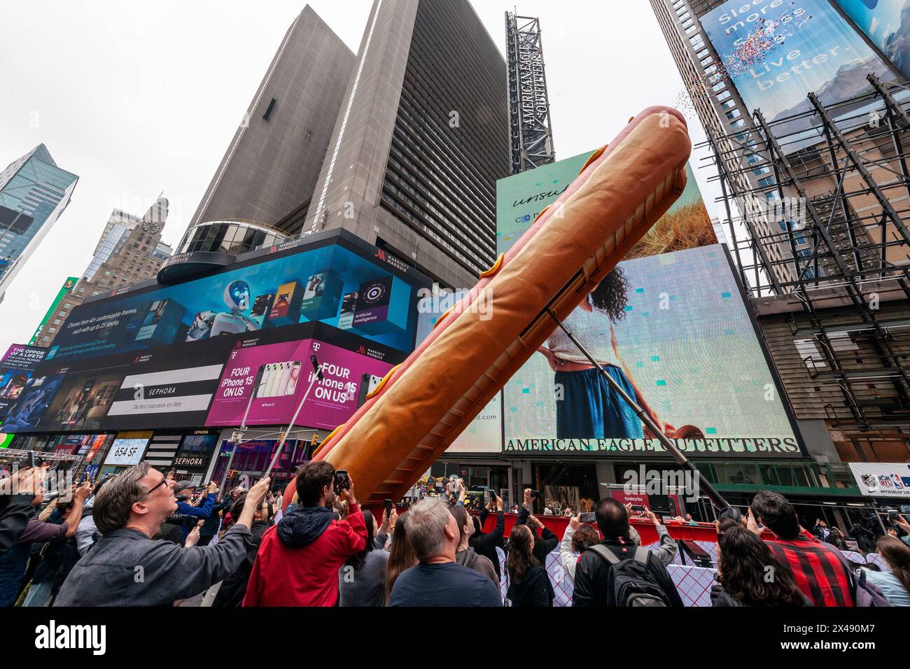 „Hot Dog in the City“ von den Künstlern Jen Catron und Paul Outlaw auf dem Times Square in New York am Dienstag, 30. April 2024. Die 65 Meter lange, animatronische Hot Dog-Skulptur hebt sich auf und ejakuliert jeden Tag mittags Konfetti. Die Installation wird bis zum 13. Juni gezeigt. (© Richard B. Levine) Stockfoto